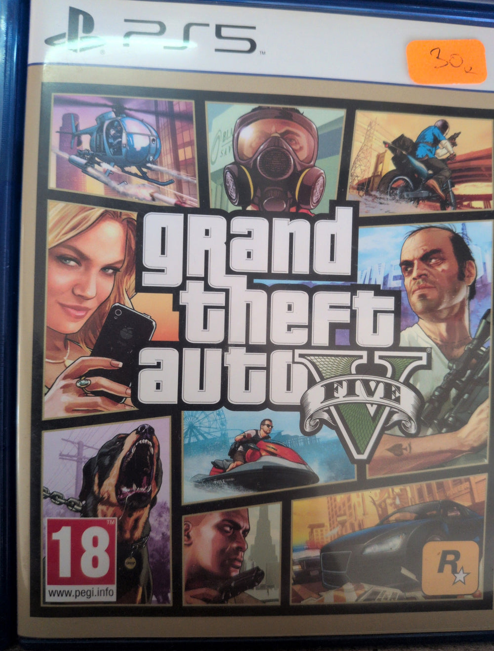 Photographed front cover and case of Grand Theft Auto V — PS5