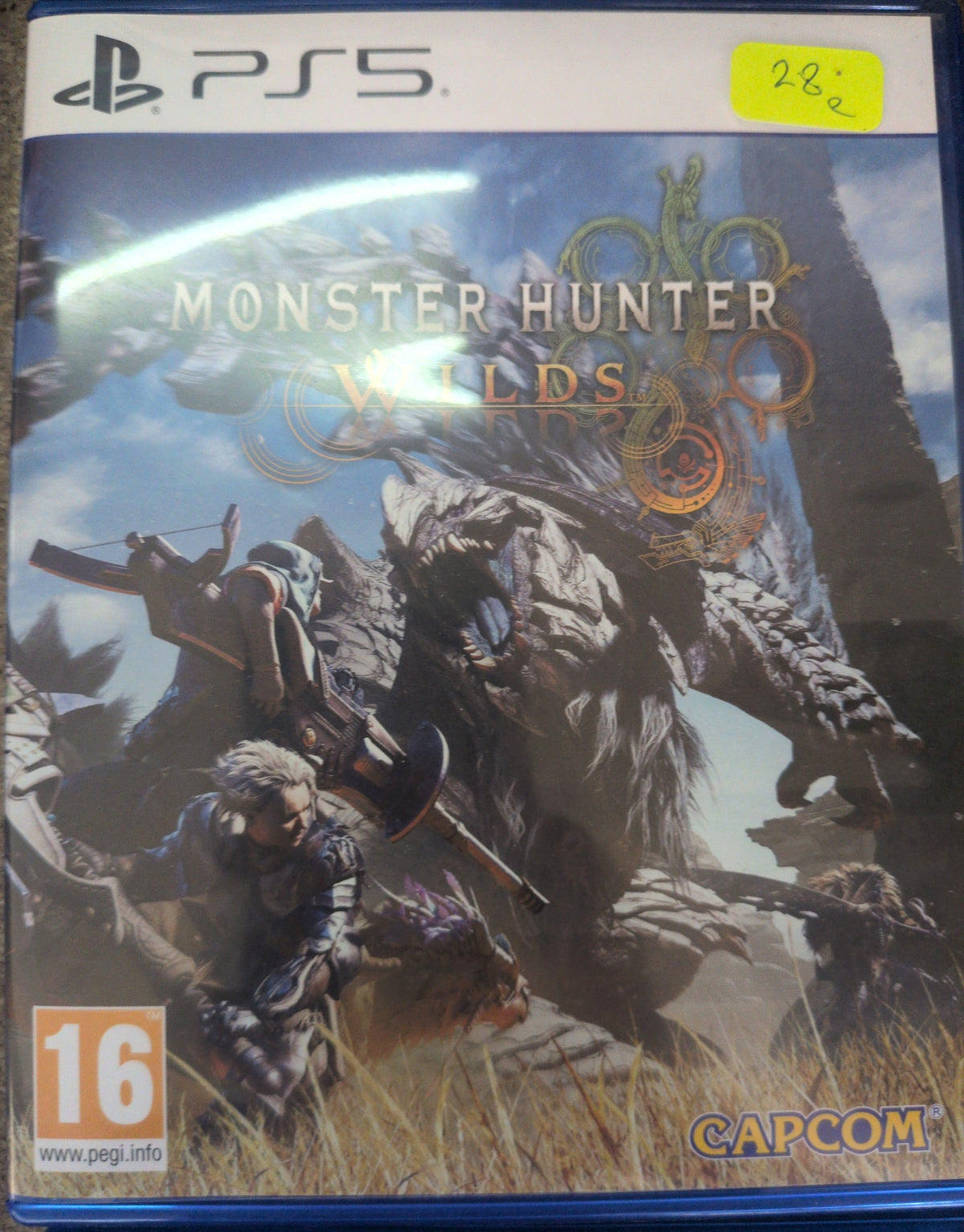 Photographed front cover and case of Monster Hunter Wilds — PS5